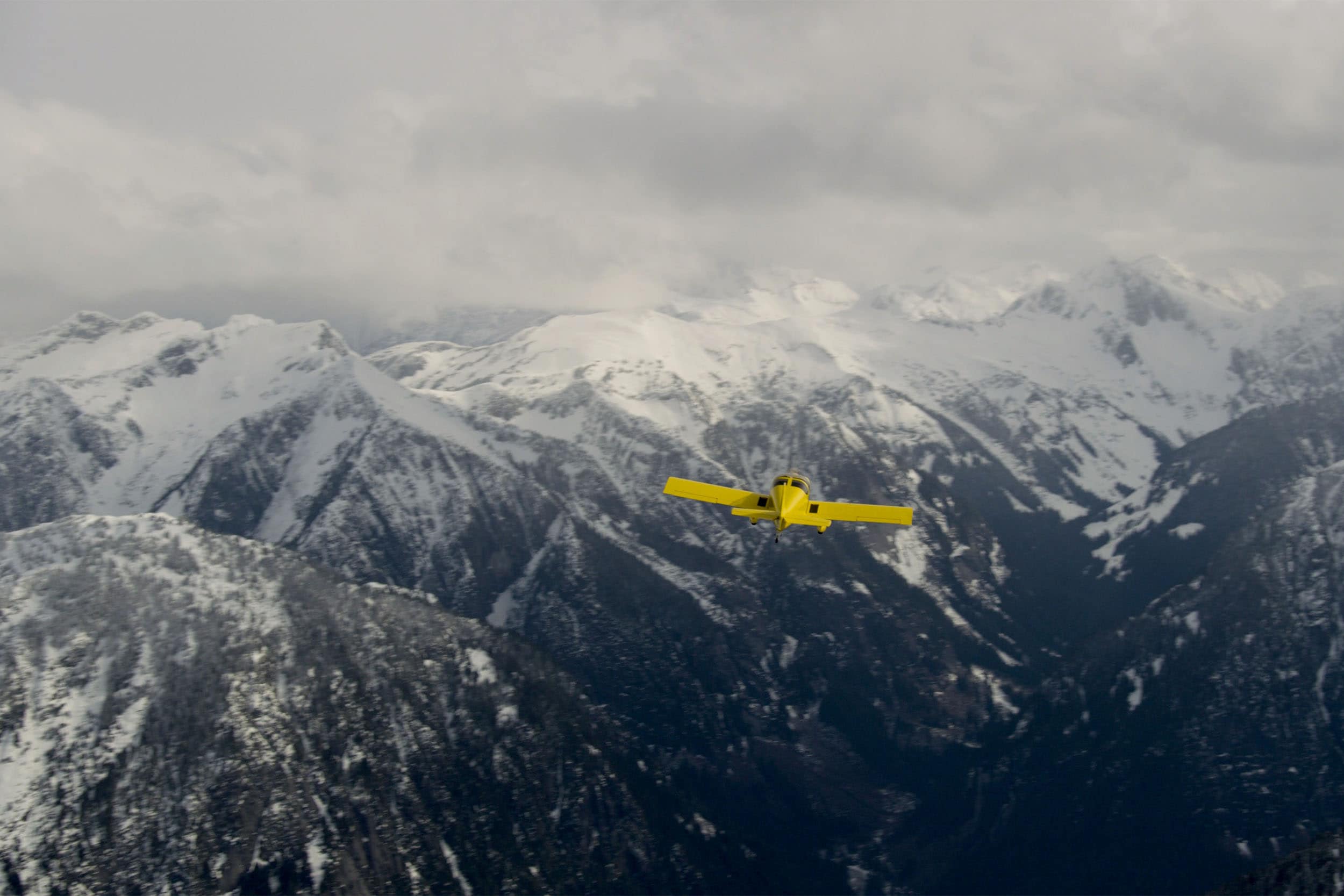 yellow airplane in mountains
